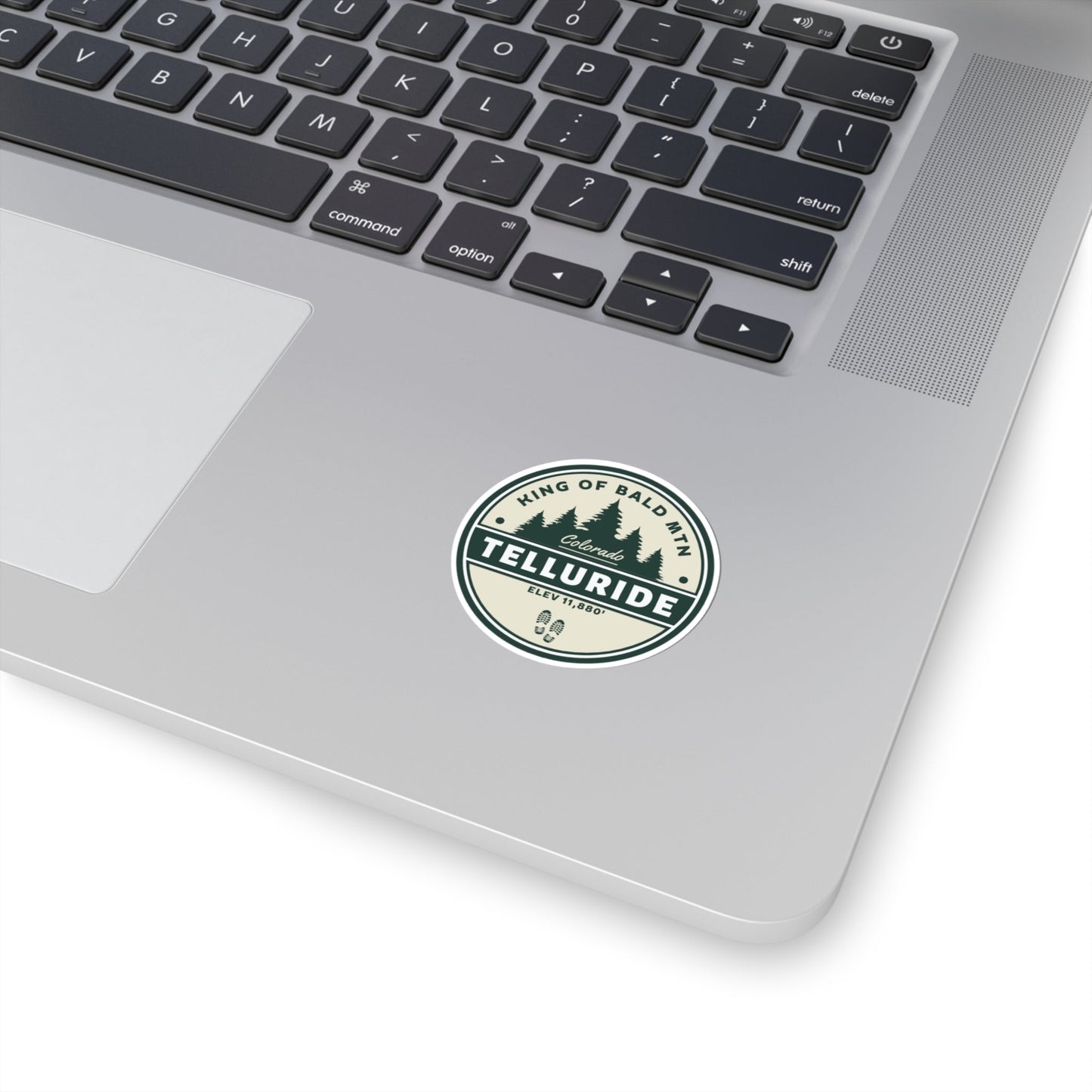 Sticker with a circle design featuring black lettering saying "King of Bald Mtn.", Telluride, CO. and Elevation 11,880'. The sticker is made of durable vinyl and is perfect for sticking to laptops, water bottles, or other belongings. The phrase "King of Bald Mtn." is a popular saying among skiers and snowboarders who have summited Bald Mountain, a mountain in Telluride, Colorado. This sticker a great way to show your support for the resort and the apres ski lifestyle.