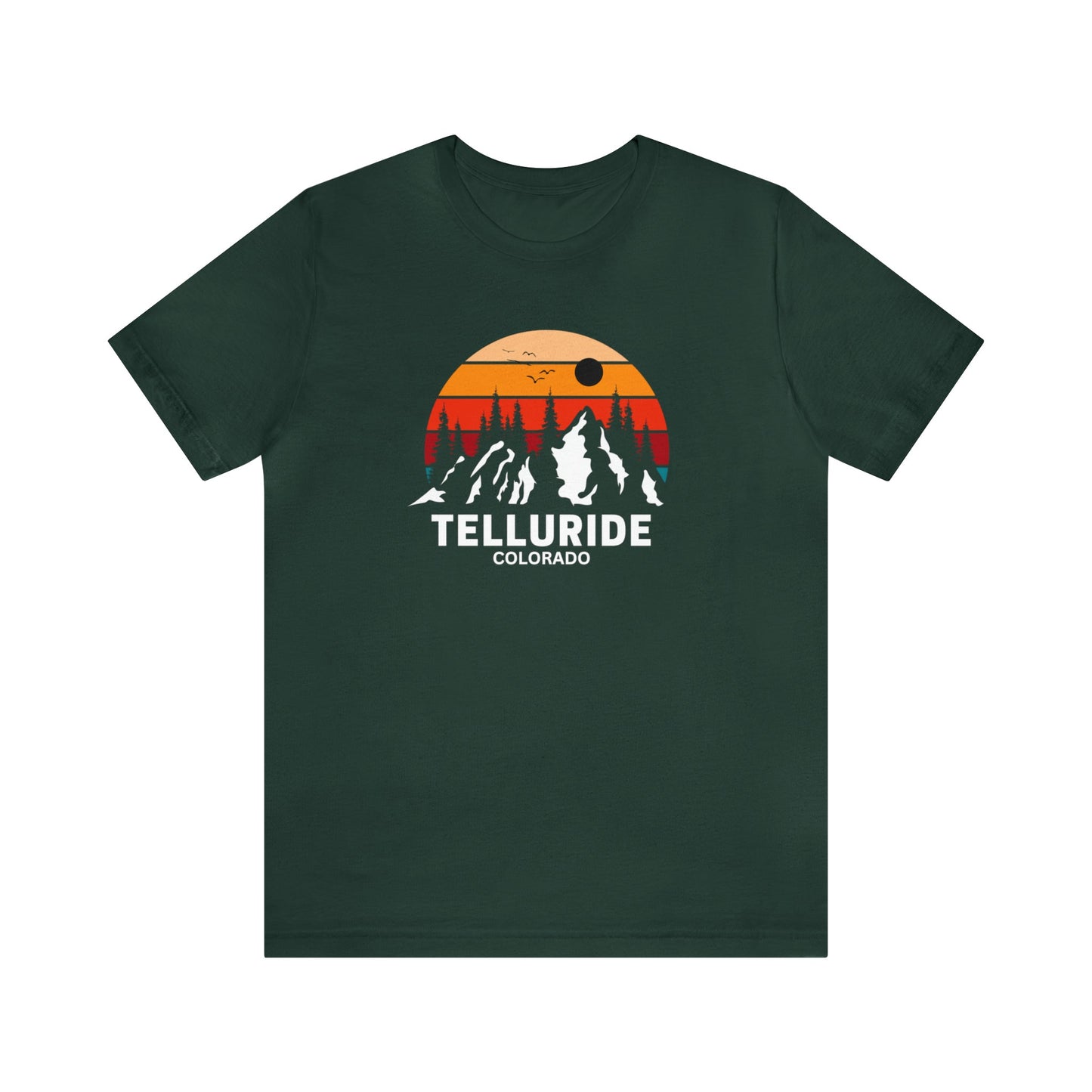 Green short sleeve unisex t-shirt with white lettering saying "Telluride Colorado". The t-shirt also has a colorful image of the mountains and a sunset in the background. The t-shirt is a stylish and comfortable way to show your love of skiing, snowboarding, hiking or shopping at the Telluride Ski Resort.