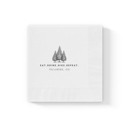 White cocktail napkins with black writing saying "Eat. Drink. Hike. Repeat.". The napkins are made of soft, absorbent paper and are perfect for use at parties, events, or just for everyday use. Celebrate your time at the Telluride Ski Resort, in the mountains and at your next wedding! 