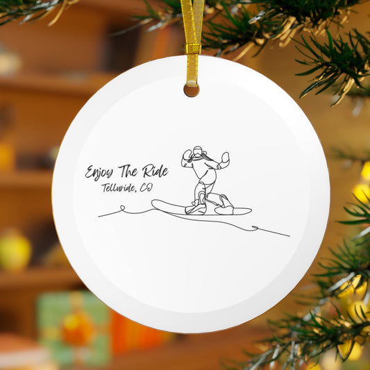 White glass ornament with black lettering saying "Enjoy the Ride" and "Telluride, Co." and an image of a snowboarder. The ornament is made of durable glass and is perfect for hanging on a Christmas tree or other holiday décor. Celebrate your incredible trip at the Telluride Ski Resort!