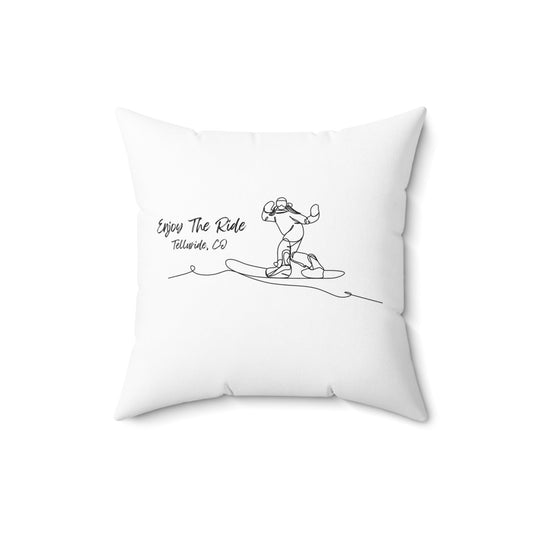 White square pillow with black lettering saying "Enjoy the Ride" and “Telluride, Co.” and an image of a snowboarder. The pillow is made of soft, comfortable fabric and is perfect for adding a touch of personality to any room. Remember your epic trip to the Telluride Ski Resort!