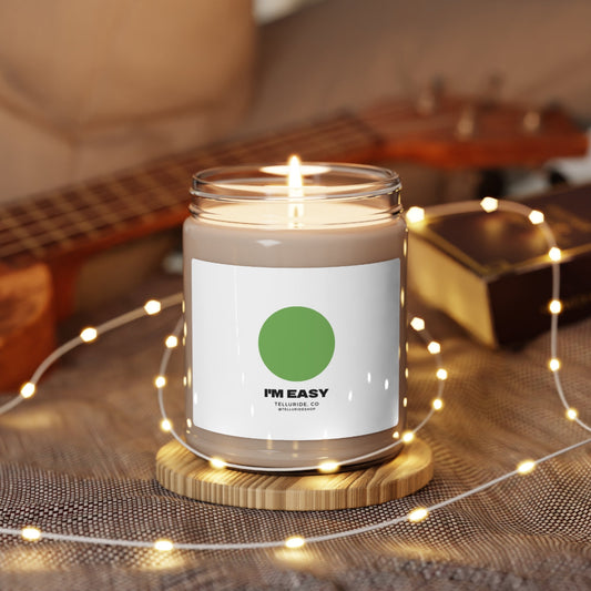 Soy candle with a white label and black lettering saying "I'm Easy" and a green circle sign. The candle is made of natural soy wax and is perfect for adding a touch of ambiance to any room.  The green circle sign is a reference to the Telluride Ski Resort's Green Circle runs, which are the easiest runs on the mountain. This candle is a great way to show your support for the resort and the ski and snowboard lifestyle.