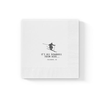 White printed birthday napkins with a skier, black lettering saying "It's All Downhill From Here" and Telluride, CO. The napkins are made of soft, absorbent paper and are perfect for use at parties or other events. The skier in the image is a reference to Telluride Ski Resort, a popular ski resort in Colorado. These napkins are a great way to celebrate a birthday or other special occasion with a touch of humor and a nod to the apres ski lifestyle.
