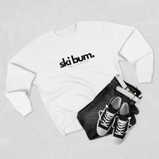 Premium white crewneck unisex sweatshirt with black lettering saying "Ski Bum" and Telluride. The sweatshirt is made of soft, comfortable cotton and is perfect for a day of skiing or snowboarding. The phrase "Ski Bum" is a popular term for someone who loves to ski or snowboard and who lives or spends a lot of time in a ski resort town. This sweatshirt is a great way to show your love of skiing and snowboarding, and your love of the Telluride Ski Resort. 