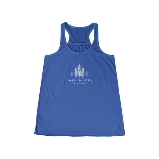 Blue women's flowy racerback tank with white lettering saying "Take A Hike" and Telluride. The tank top is made of 100% cotton and is perfect for a day of hiking or skiing. The phrase "Take A Hike" is a popular saying among hikers and skiers, and the words "Telluride" represent the beauty of the Telluride Ski Resort. This tank top is a great way to show your love of the outdoors and your love of Telluride.