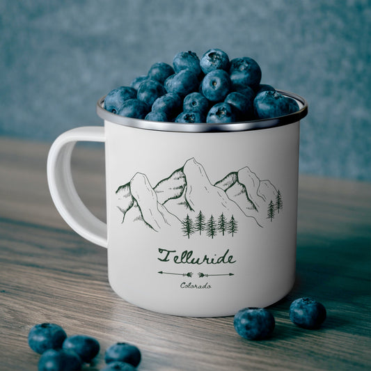 White lightweight stainless steel mug with a green print of mountains, trees, and the words "Telluride" and "Colorado". The mug is a stylish and practical way to enjoy a beverage while celebrating your love of the Telluride Ski Resort and Colorado. The white mug is lightweight and durable, making it easy to take with you on your next adventure and a great reminder of the special place that this town holds in your heart.