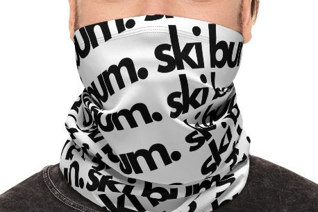 Winter neck gaiter with the words "Ski Bum" printed in black on a white background. The neck gaiter is a stylish and practical way to keep your neck warm and protected from the elements while celebrating your love of skiing and the Telluride Ski Resort. The neck gaiter is a great way to show your love of Telluride and Colorado, whether you're a ski bum or not.